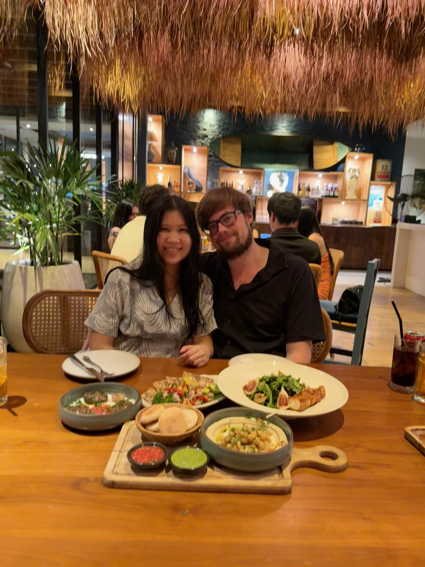 Lewis and Gail smiling together at a table full of food.