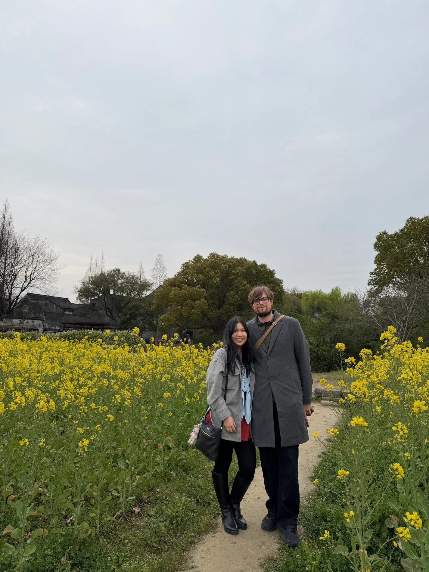 Lewis and Gail together at the edge of a yellow flower field.
