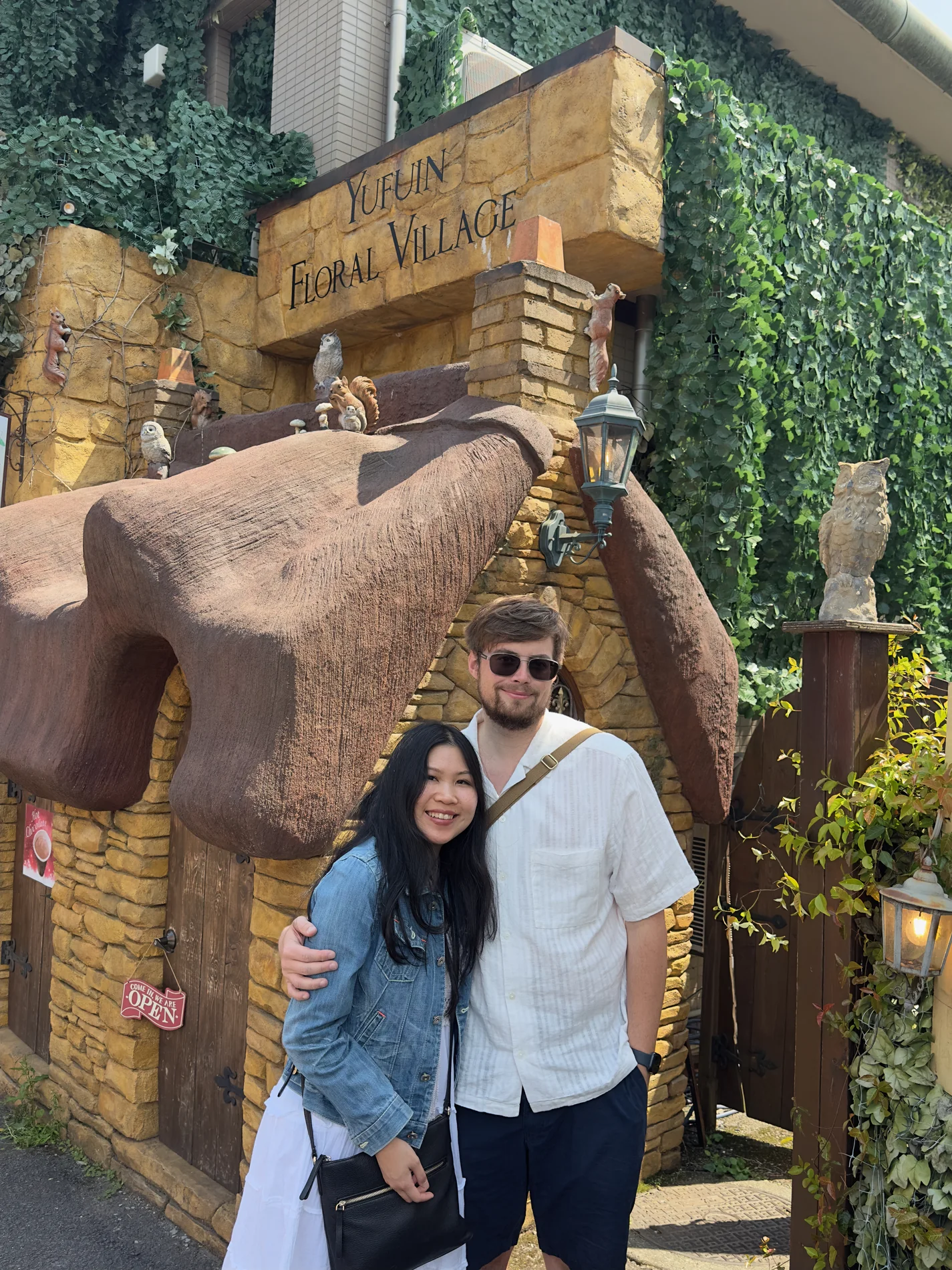 Lewis and Gail posing playfully beside an elephant statue.