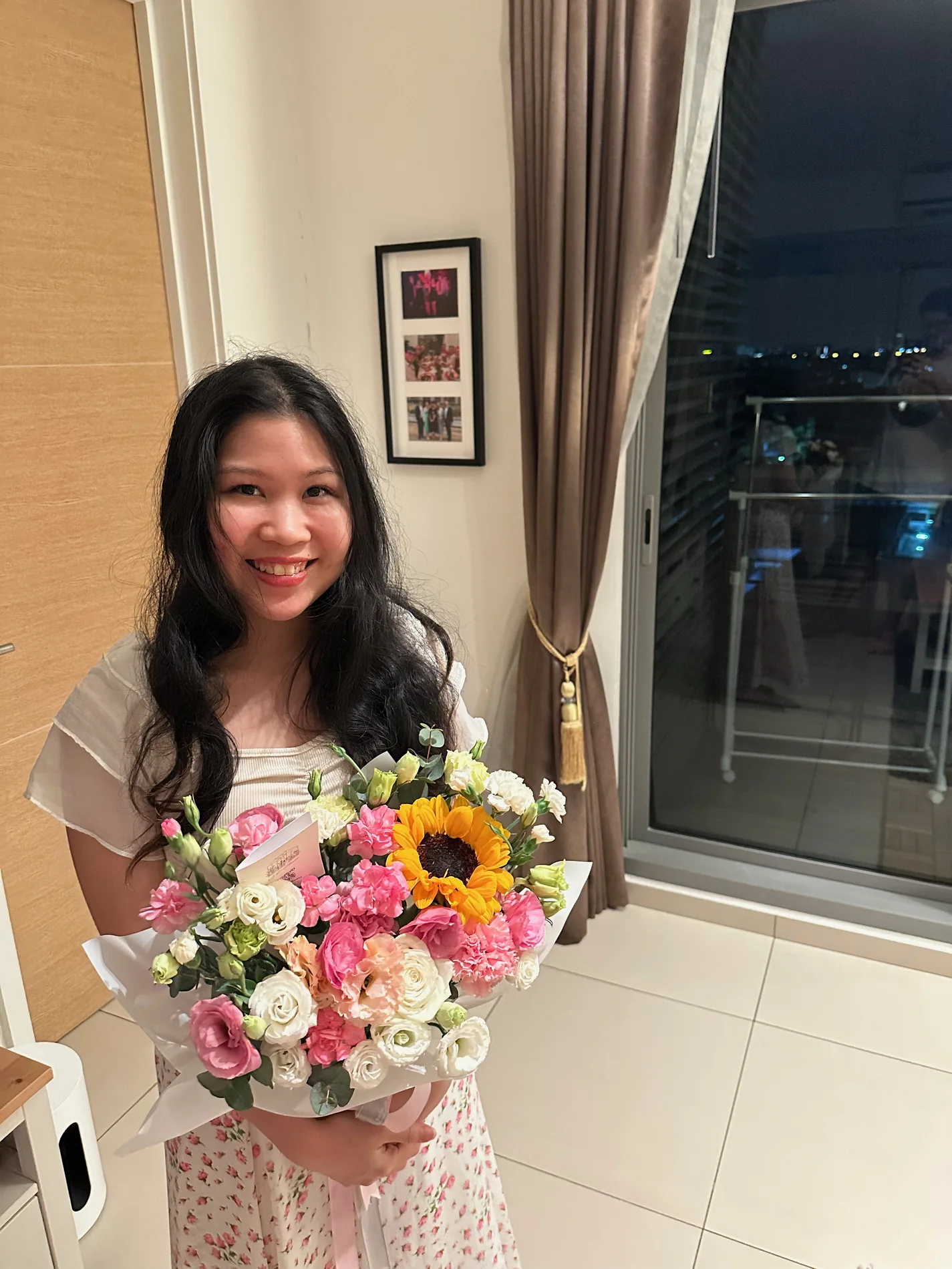 Gail smiling while holding a colourful bouquet of flowers.
