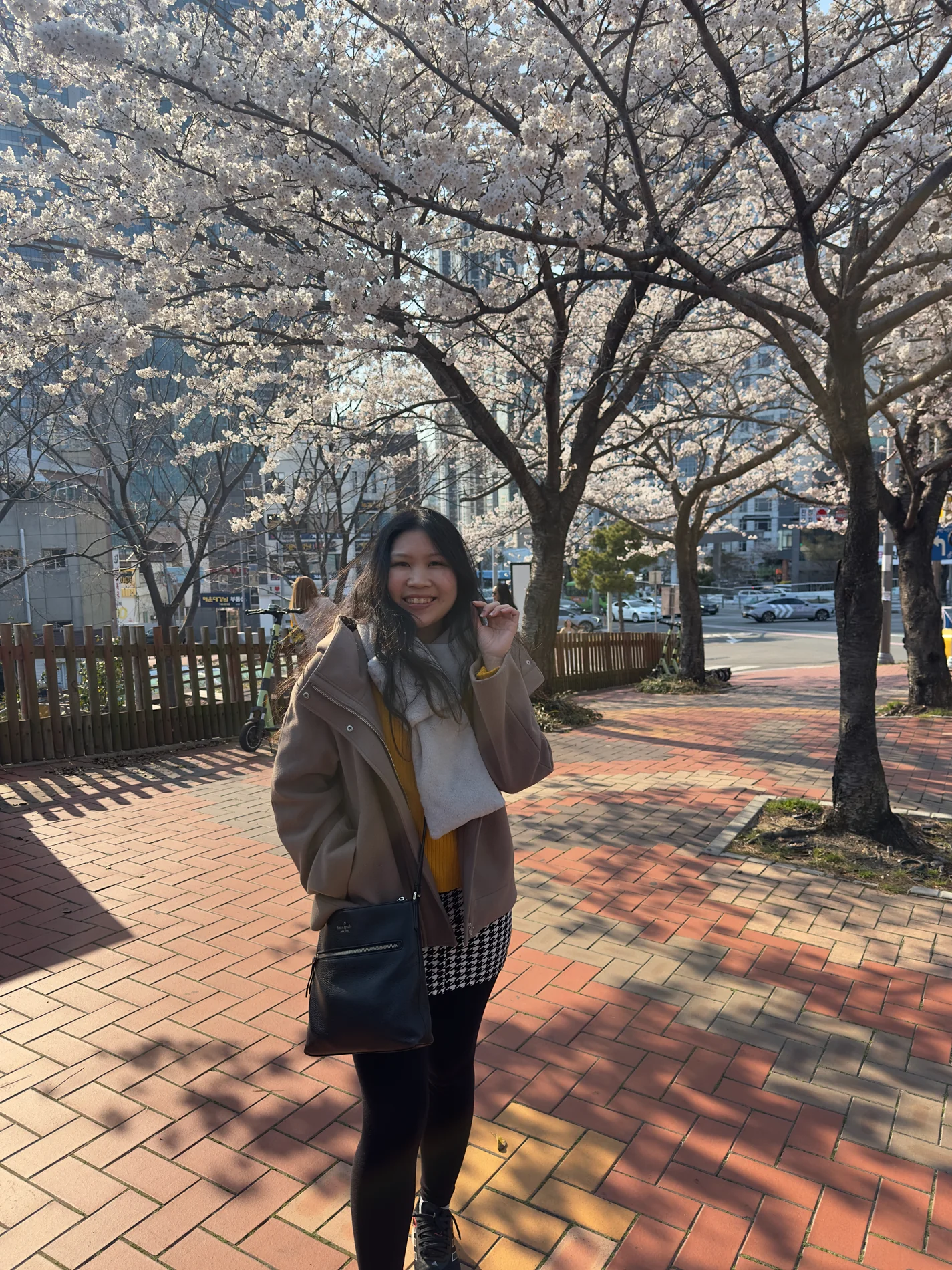Gail smiling beneath spring blossoms.