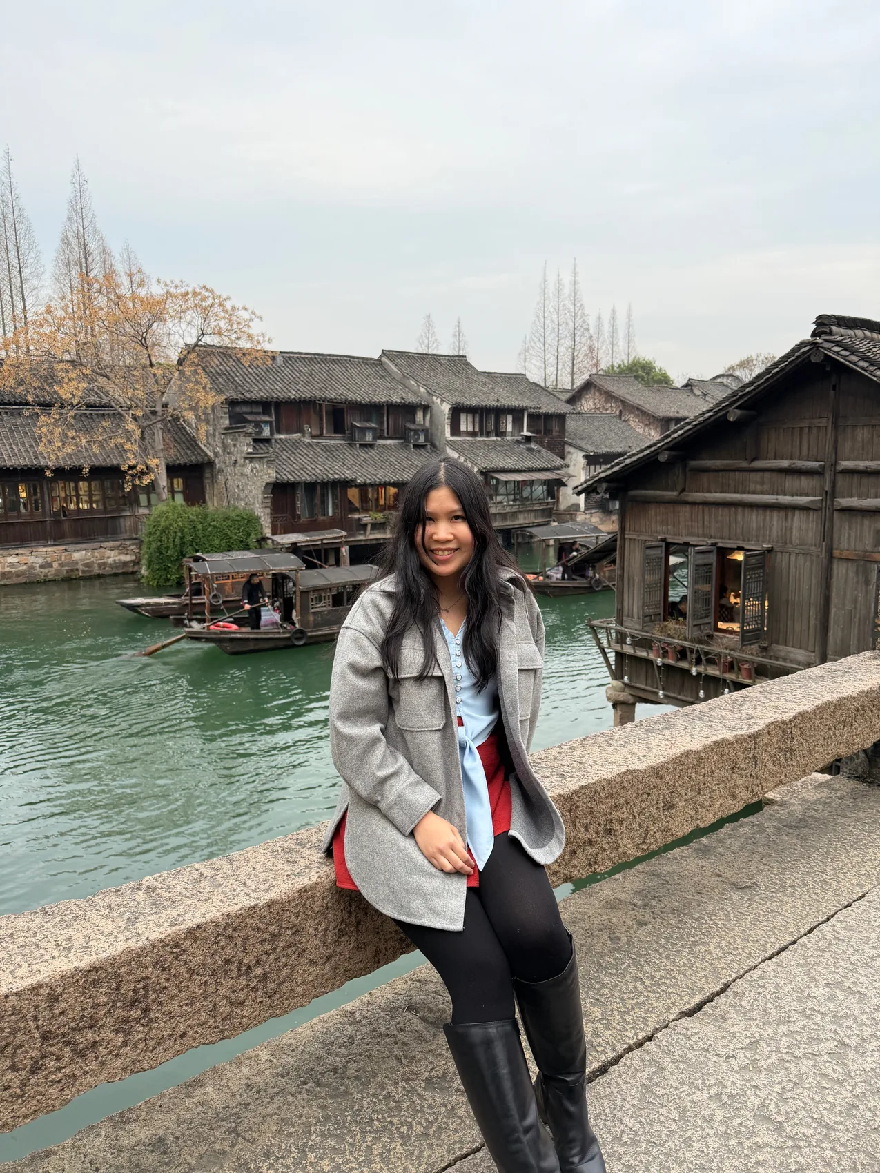 Gail smiling beside a canal and old buildings.