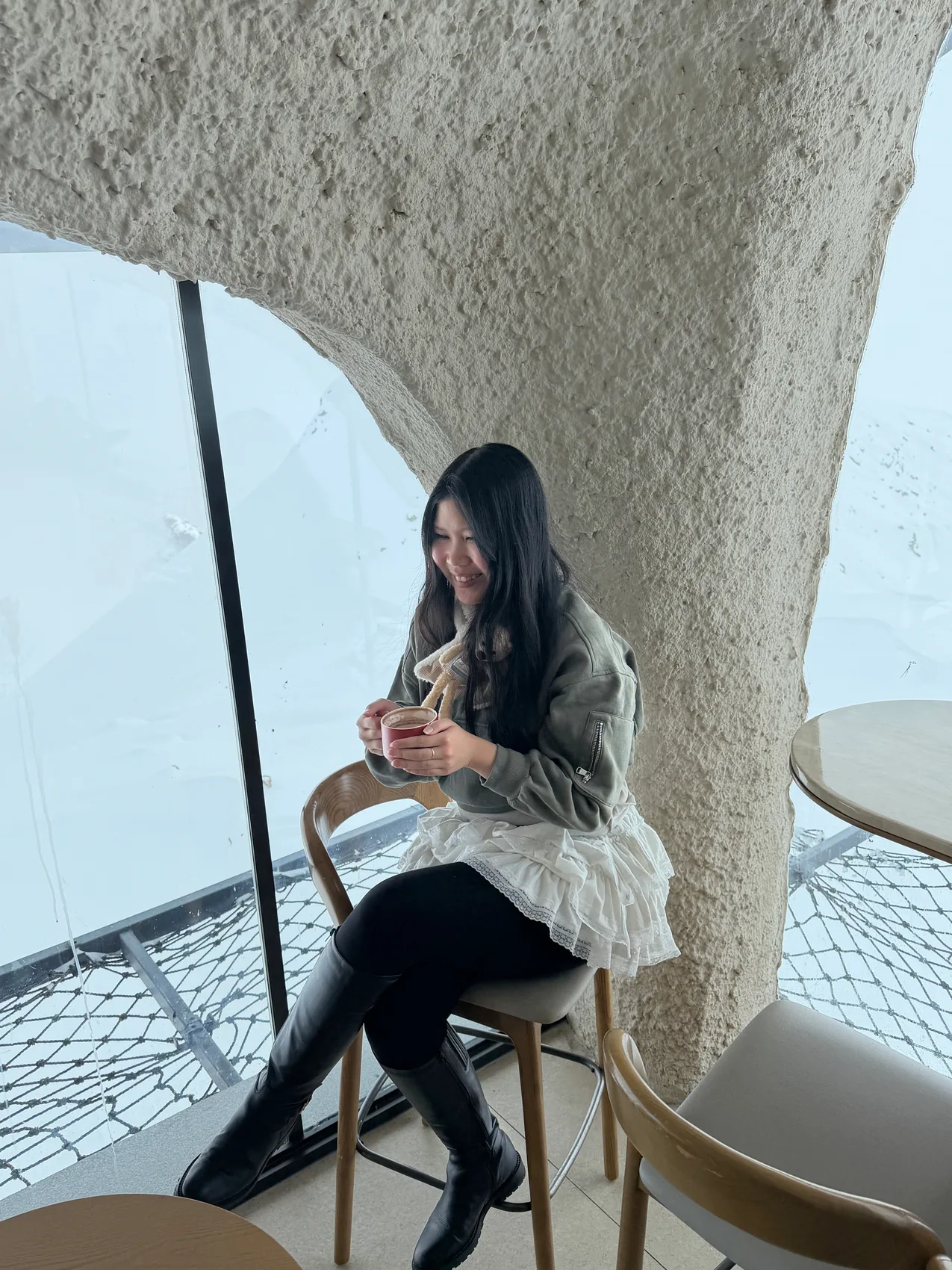 Gail sitting by a window with a mountain view.
