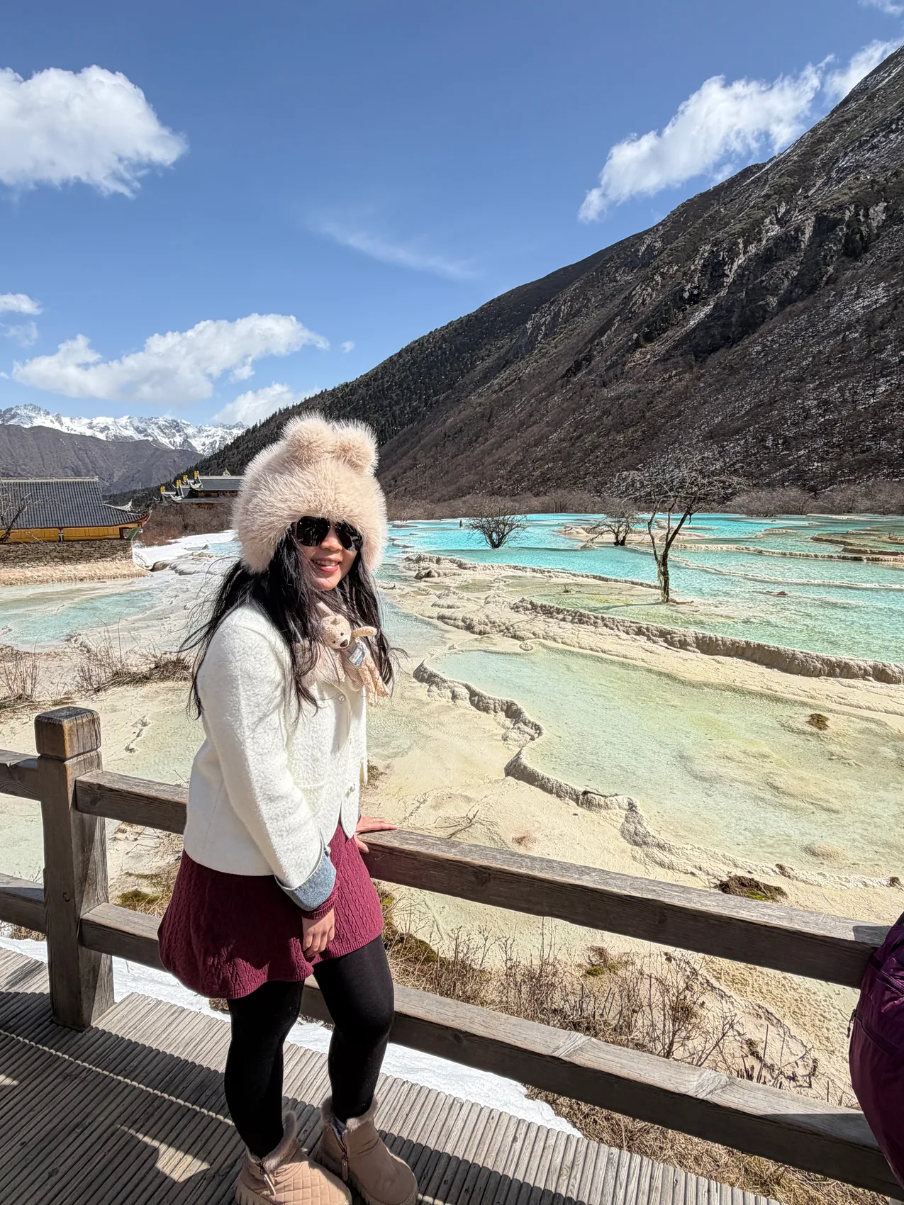 Gail smiling beside colourful mountain pools.