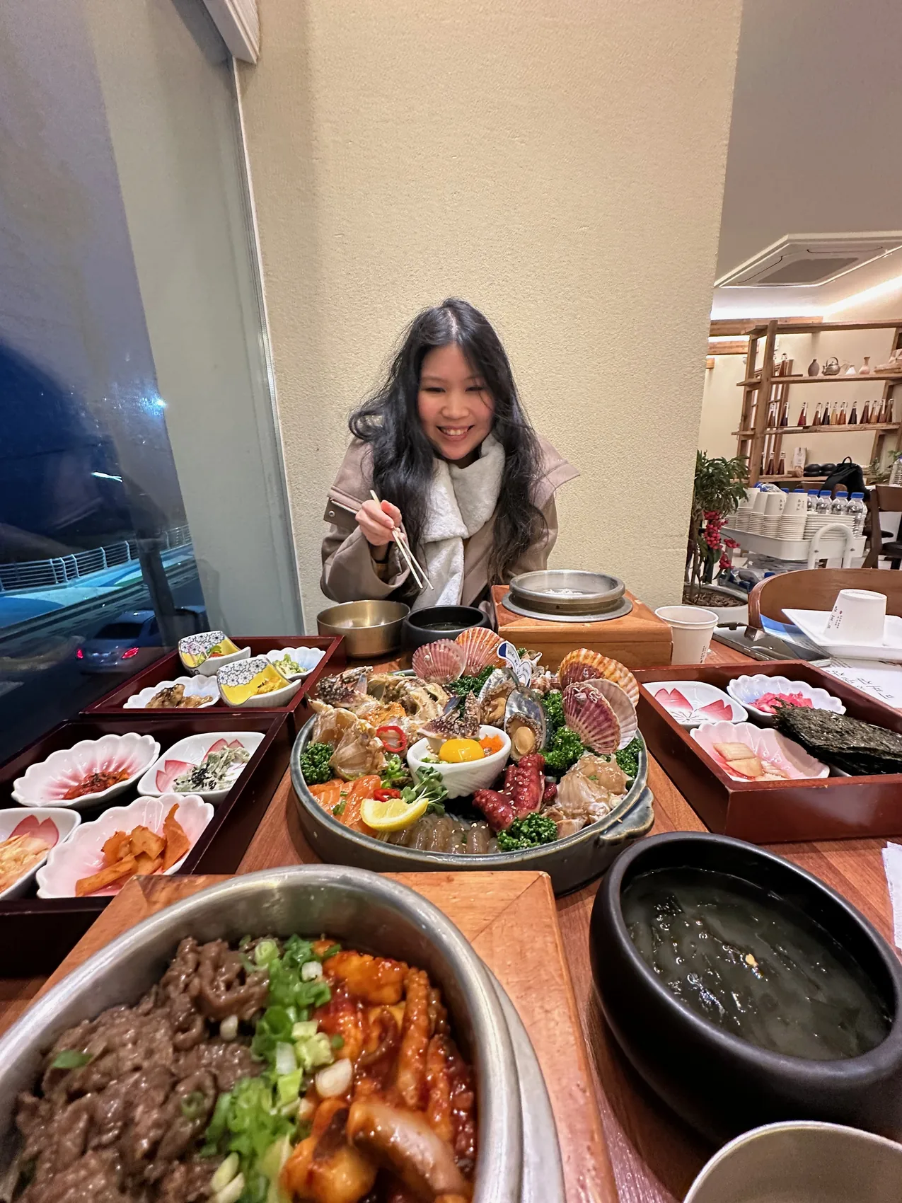 Gail laughing at a table full of food.