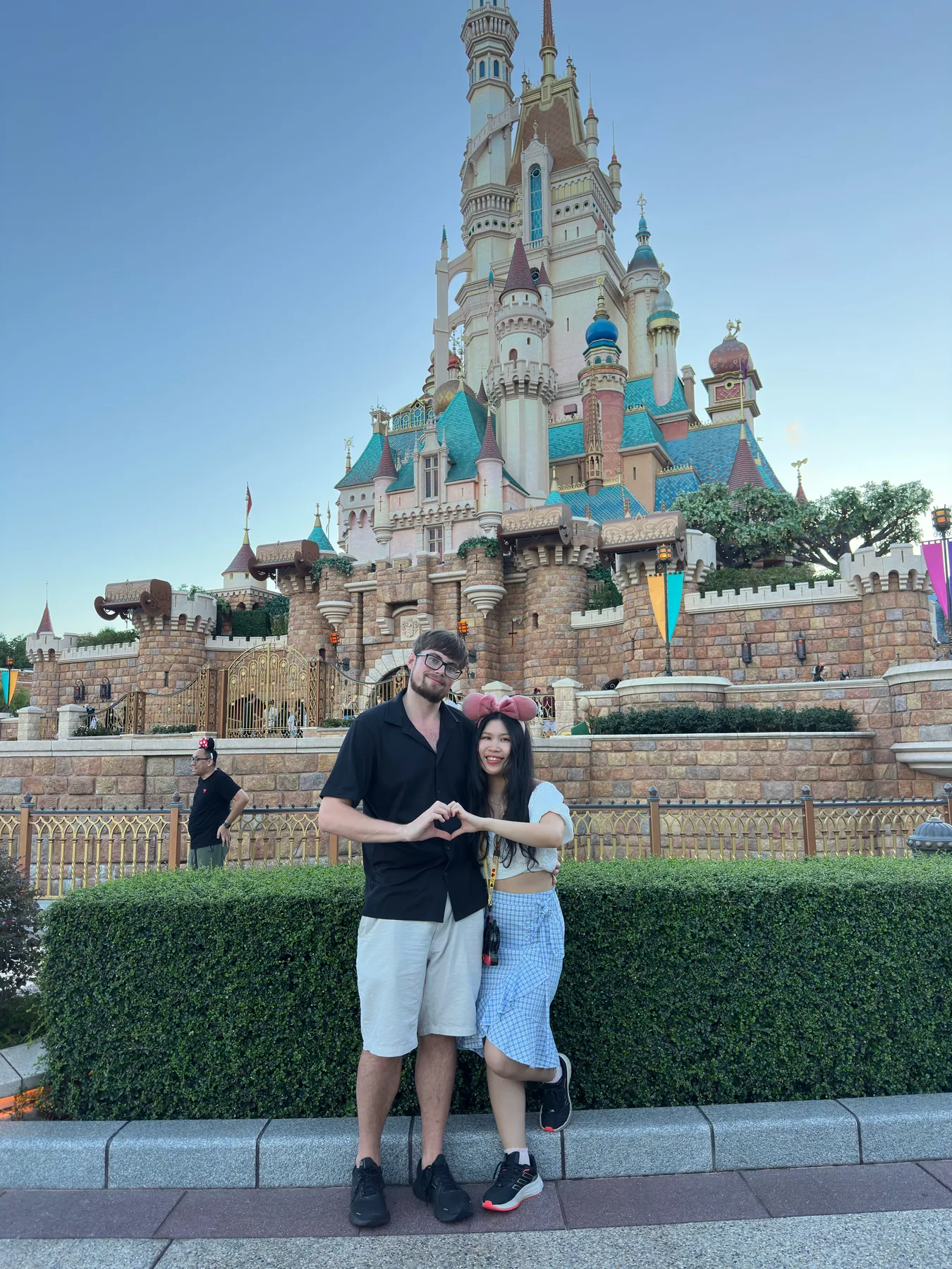 Lewis and Gail standing together in front of a fairytale castle.