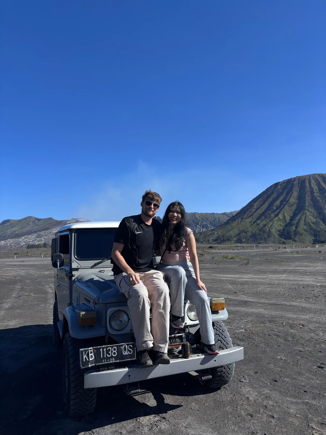 Lewis and Gail sitting together on an off-road vehicle in the mountains.