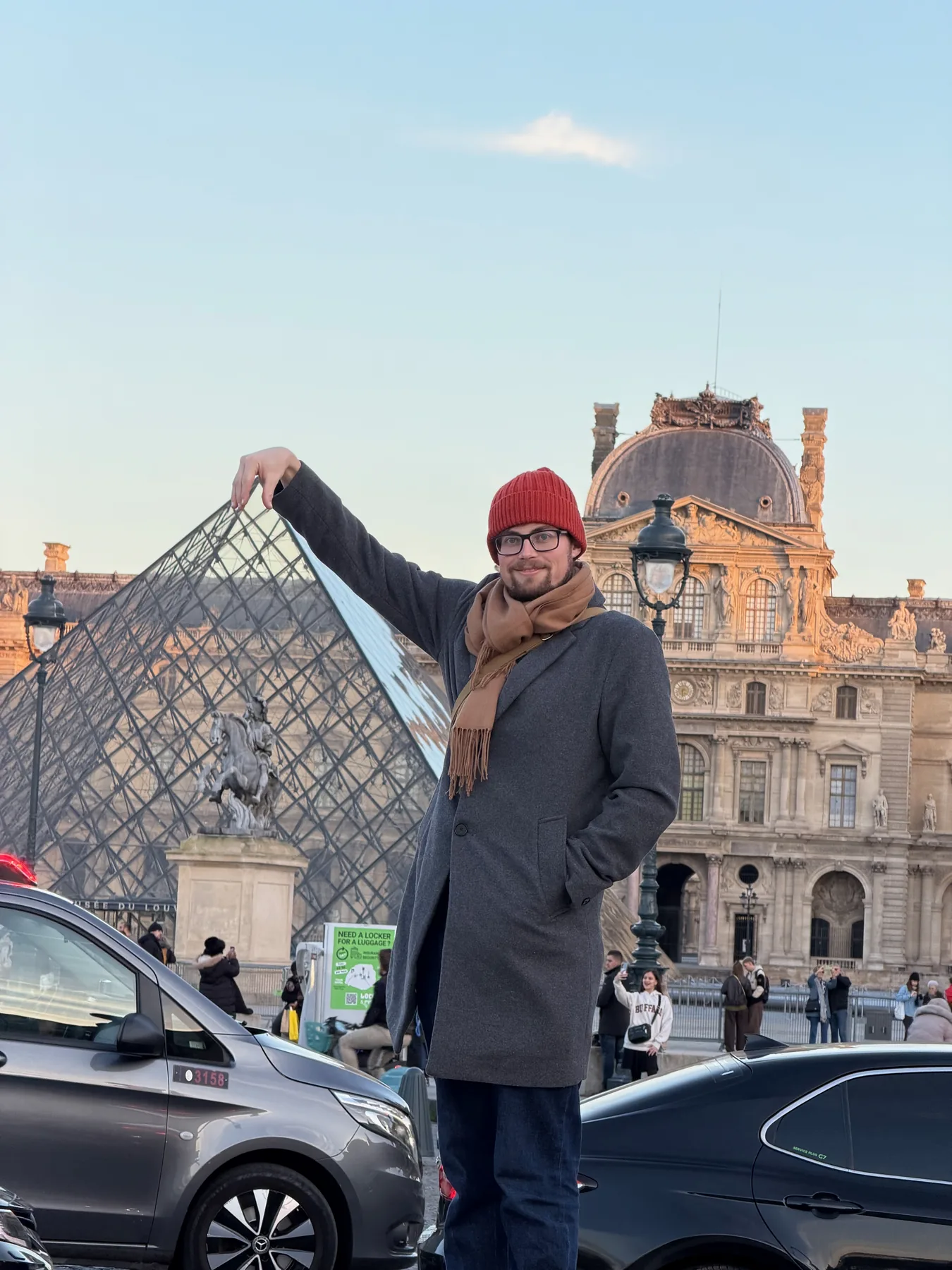 Lewis pointing toward the glass pyramid outside the Louvre.