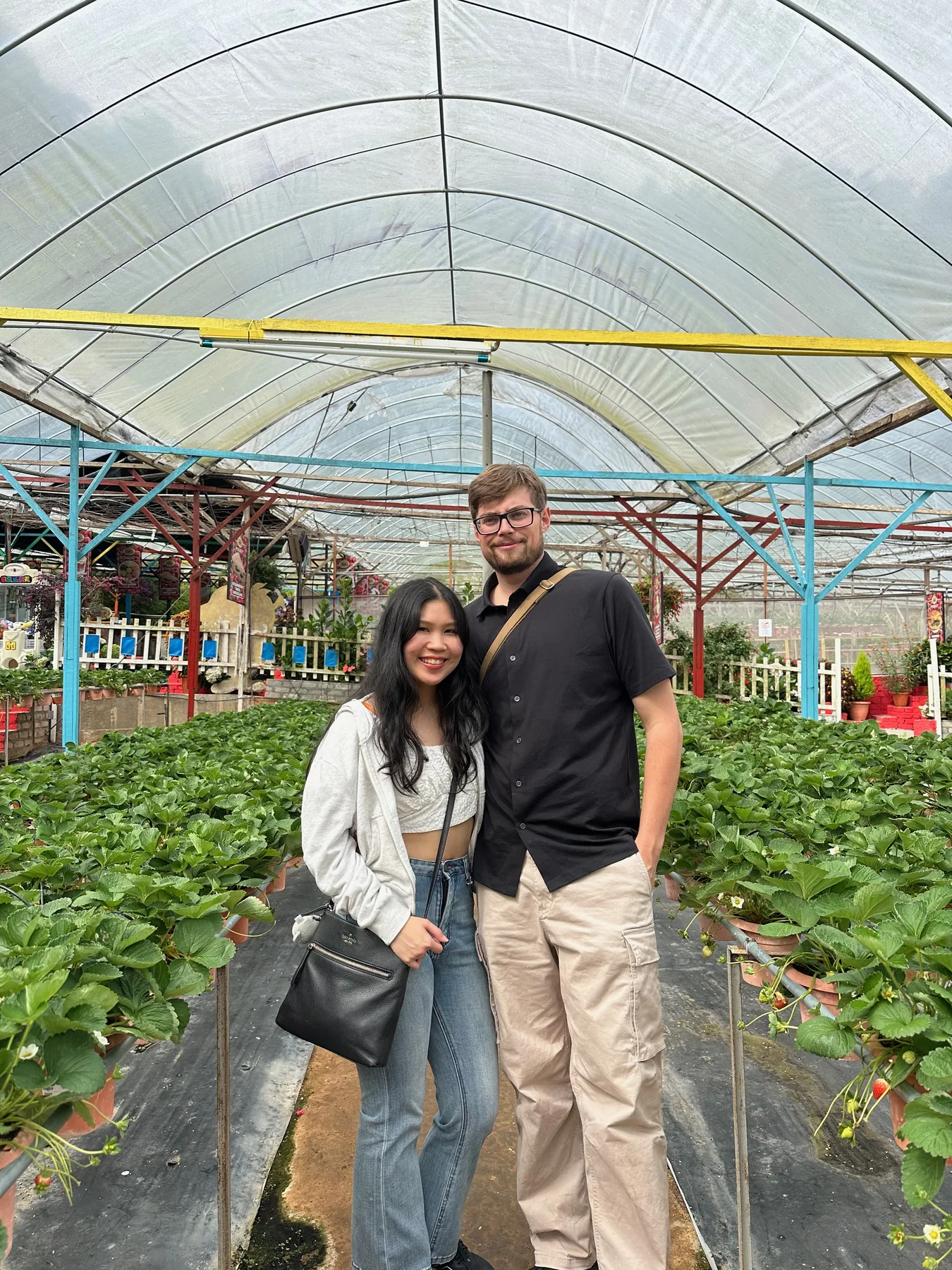 Lewis and Gail standing together in a strawberry greenhouse.